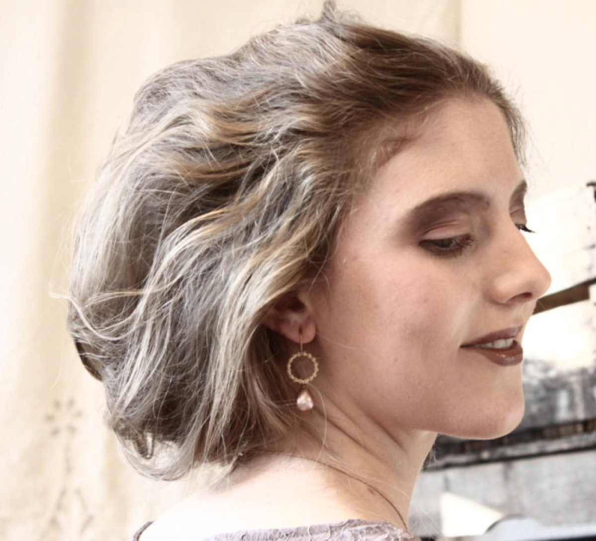 Porträt einer Frau mit den ‚Blossom Allure‘-Ohrringen von Doll Up Sister – roségoldplattierter Ohrschmuck mit Perle Porträt einer Frau mit den ‚Blossom Allure‘-Ohrringen von Doll Up Sister – roségoldplattierter Ohrschmuck mit Perle