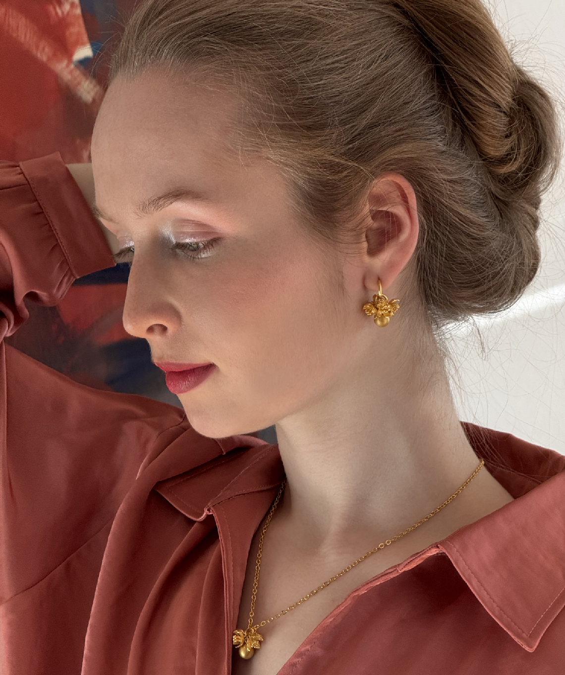 Junge Frau trägt Ohrringe und Collier aus der Kollektion Doll Up Sister von AMALA