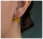 Preview: Roselle Ohrring in Gold am Ohr getragen, florales Design mit strukturierter Blütenform