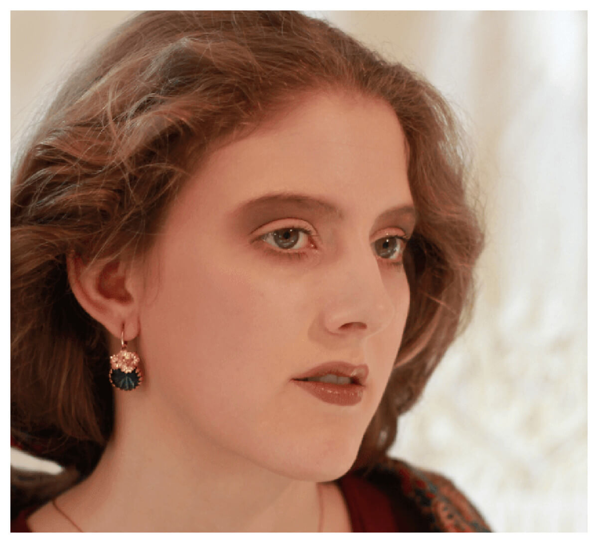 Preview: Modell trägt die Ohrhänger „Dusty Rose“ mit 750er Goldauflage und dunkelblauem Stein.