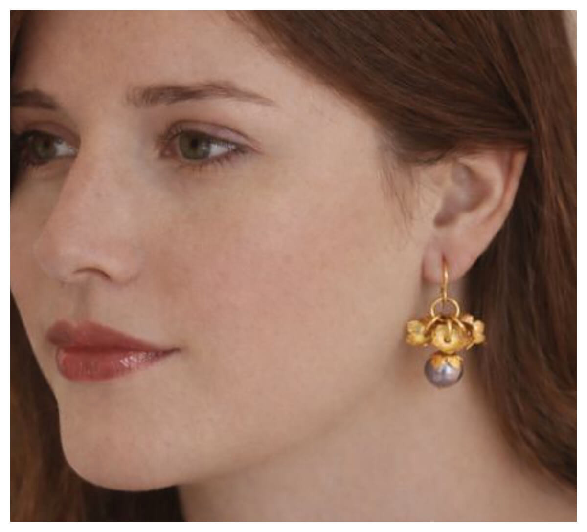 Preview: Das Modell trägt die Ohrhänger „Pompadour“ mit 750er Goldauflage und mauvefarbener Perle.