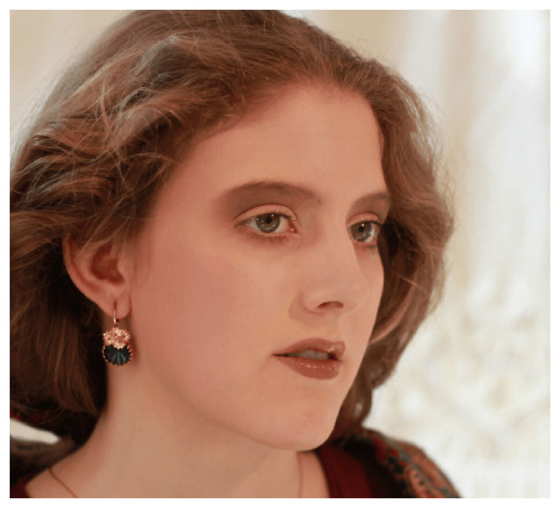 Modell trägt die Ohrhänger „Dusty Rose“ mit 750er Goldauflage und dunkelblauem Stein.