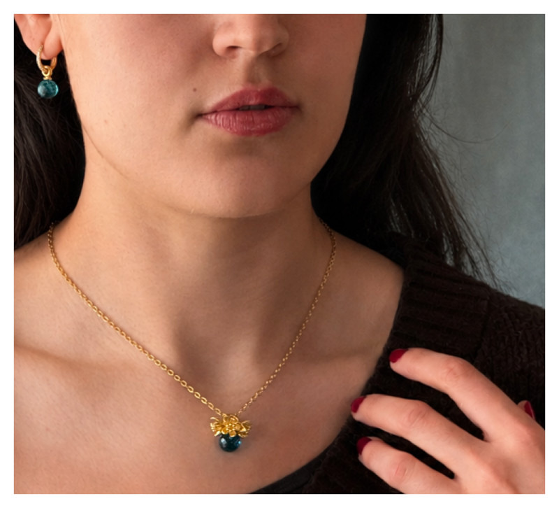 Am Modell getragenes Cherry-Bloom-Collier von Doll Up Sister mit emeraldfarbener Hydroquarzkugel und 750er Goldauflage.