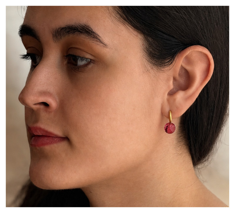 Modell im Profil mit „Luna Orb“ Ohrringen in Pink. Creolen mit Goldauflage und Hydroquarzkugel.