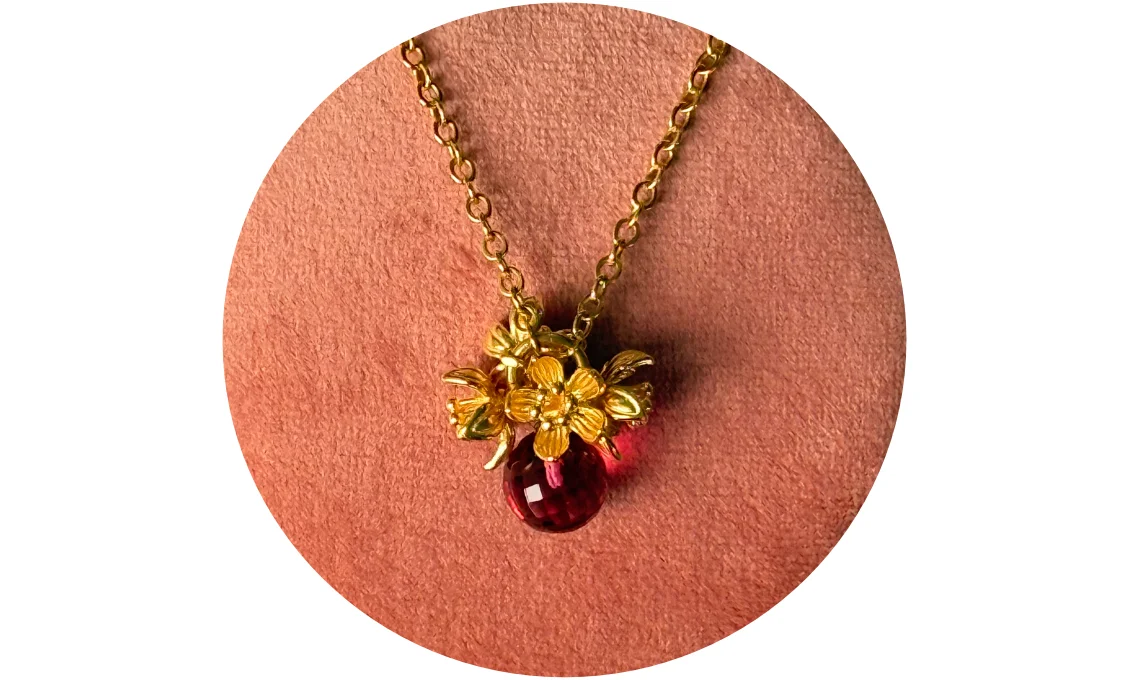Halsschmuck ansehen Goldene Halskette mit Blütenanhänger und pinken Stein